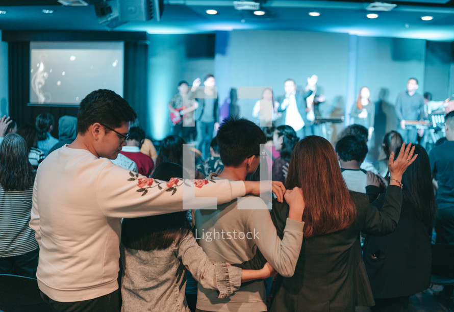 arms around each other during a worship service 