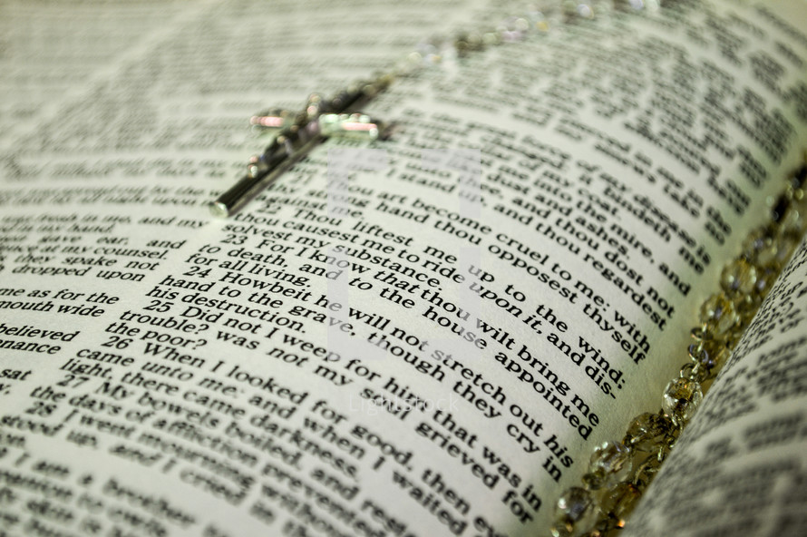 rosary on the pages of a Bible 
