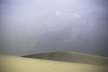 sand dunes in a desert and distant mountains 