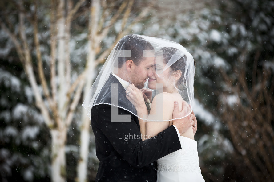 bride and groom kissing in the snow