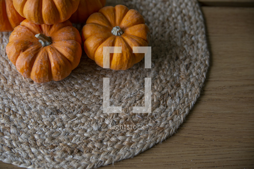 Little pumpkins on braided placemat