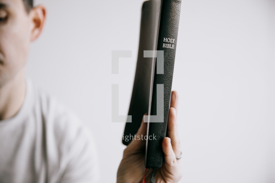 a man holding up a Bible 