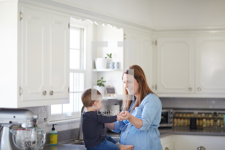a mother in the kitchen with her toddler son 