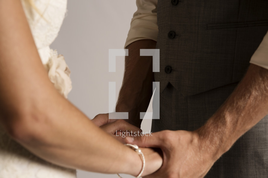 bride and groom holding hands in a portrait 