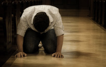 man kneeling on a church floor