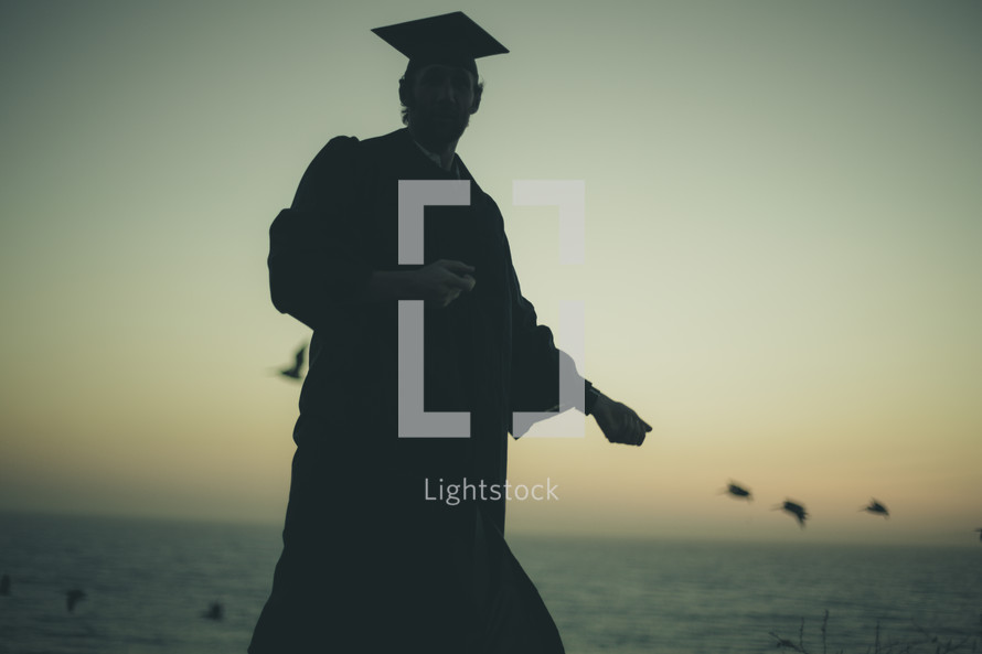 silhouette of a graduate on a beach