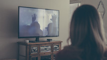 a woman watching a worship service streamed to her tv