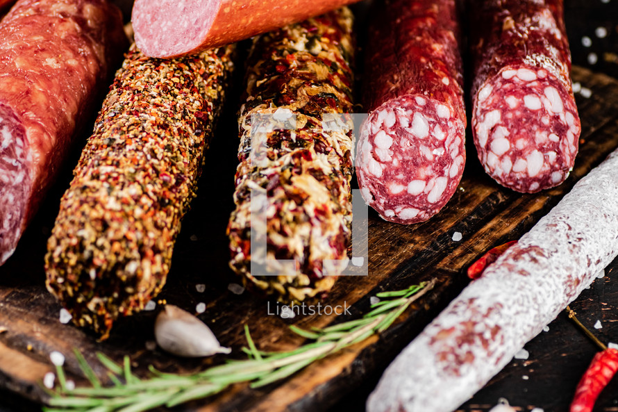 Assortment of various aromatic salami sausages. Against a dark background. High quality photo