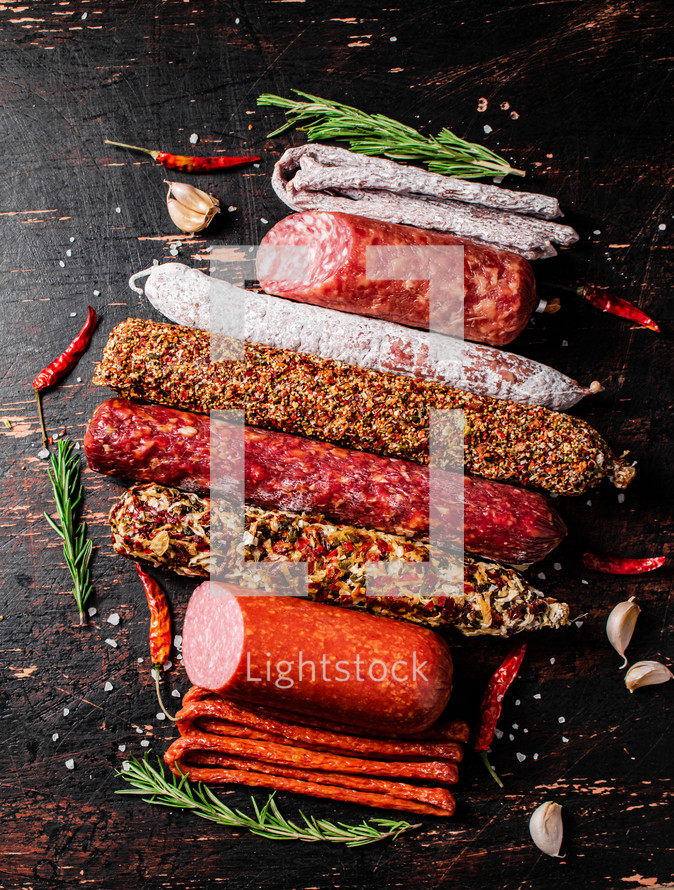 Assortment of various aromatic salami sausages. Against a dark background. High quality photo