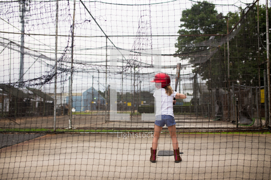 a girl in a batting cage 