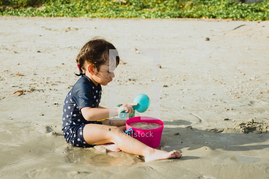 a child playing in the sand on a beach 