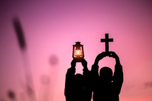 Two children holding oil lamp and cross with light sunset background,christian