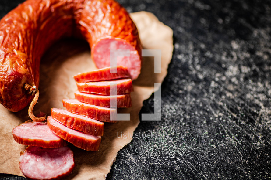 Delicious salami sausage on the table. On a black background. High quality photo