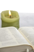 burning candle and an open Bible