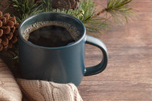 coffee cup and sweater with pine branch 