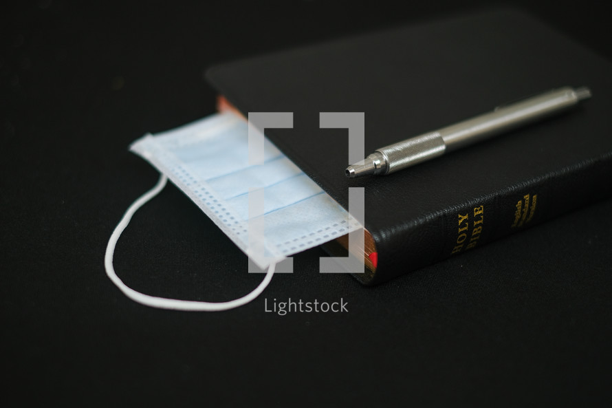mask between the pages of a Bible 