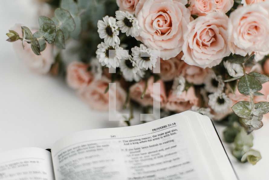 pink flower arrangement and an open Bible 