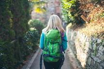 woman backpacking on a paved path 