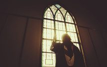 graduate standing in front of a church window