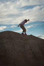 child balancing on the edge of a sand dune 