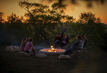 teens sitting around a campfire 