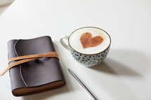cinnamon heart in a coffee cup, pen, and Leather bound journal 