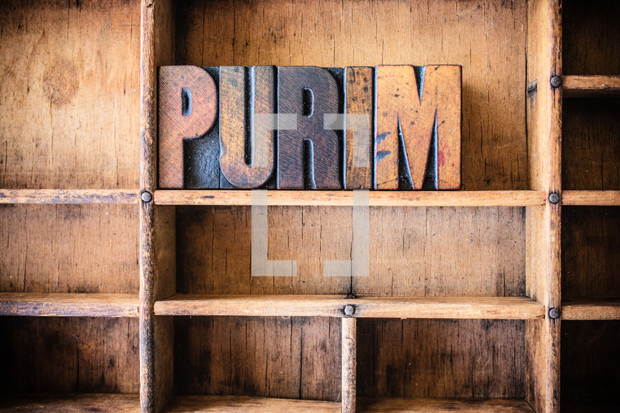 Wooden letters spelling "purim" on a wooden bookshelf.
