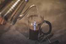 Pouring hot water to brew coffee in a french press