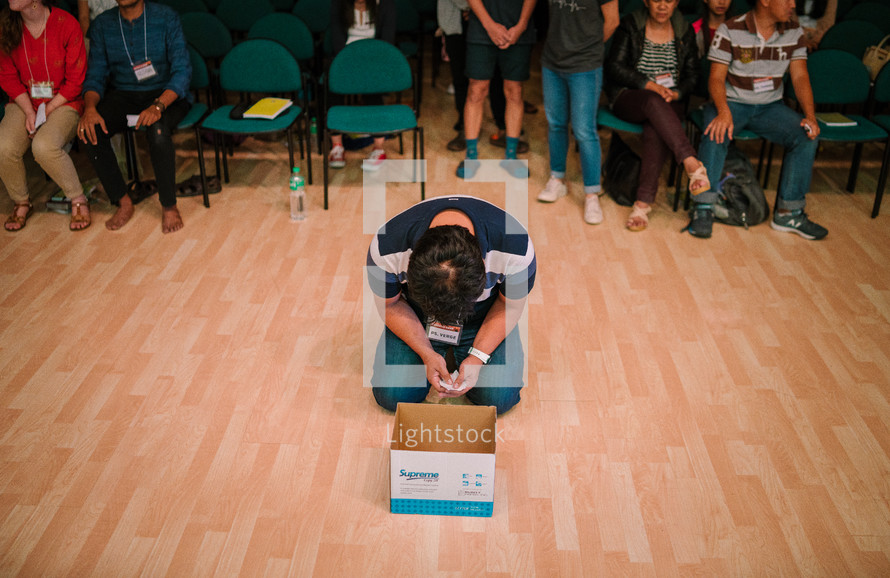 a man placing his sins in a box during a worship service 