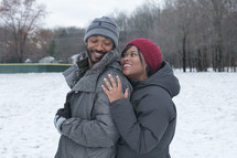 a couple hugging outdoors in snow 