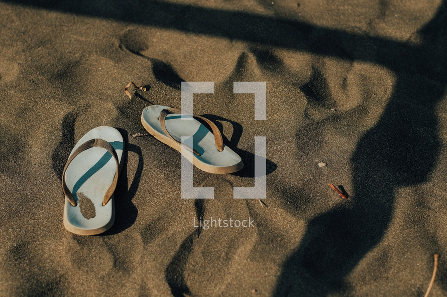 flip flops in the sand and shadows 
