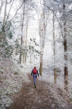 a woman hiking up a winter path 