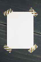 blank piece of paper with gold and white tape 
