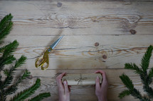wrapping Christmas presents with a pine border 
