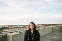 a woman standing at the top of a parking garage 