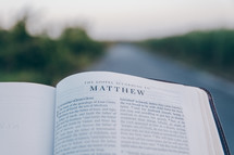 Bible opened to Matthew outdoors 