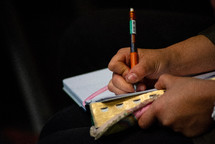 person writing in a notebook 