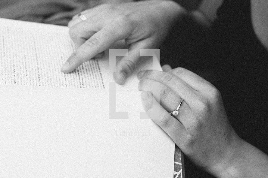 woman reading a book and pointing to the words on a page