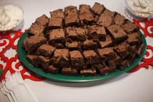 A plate piled with brownies on a table.