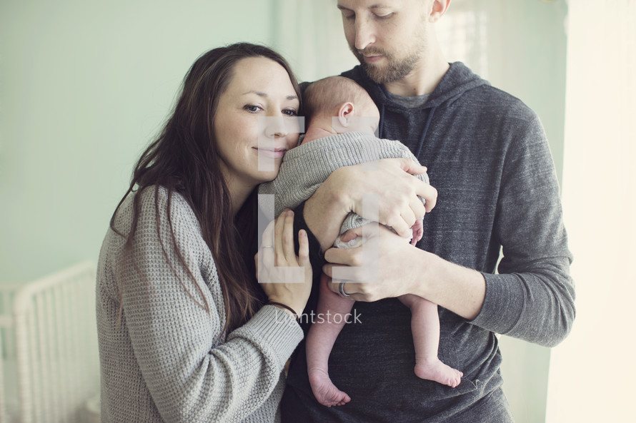 Husband and wife hold infant.