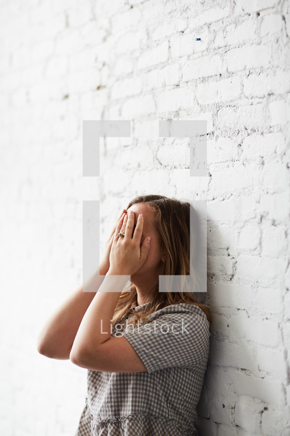 a crying woman covering her face 