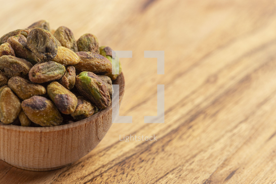 Roasted and Salted Pistachios without Shells on a Wood Table