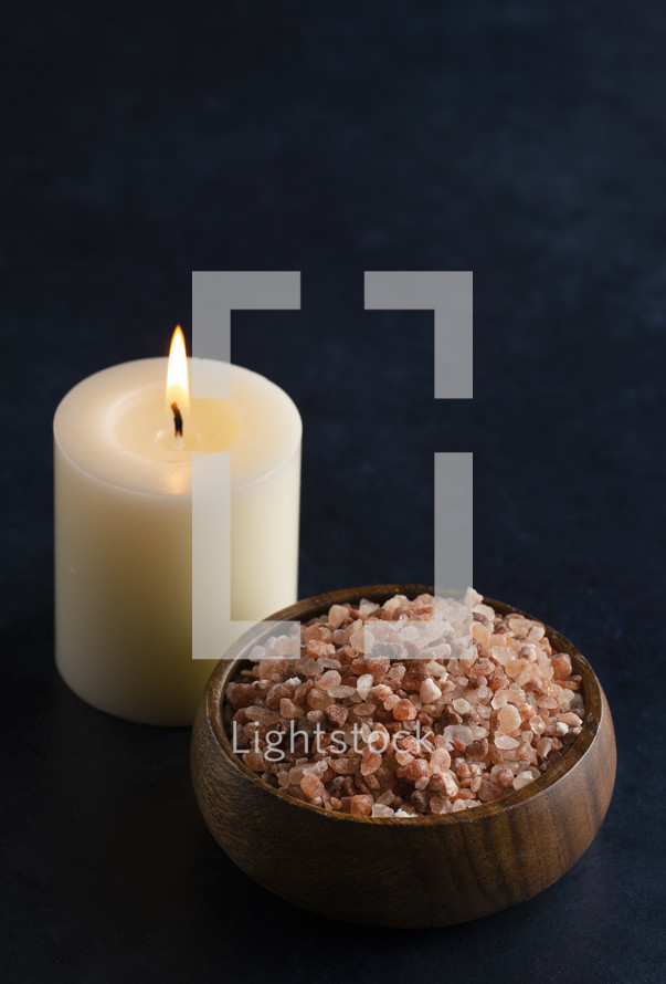 candle and bowl of pink Himalayan salt 