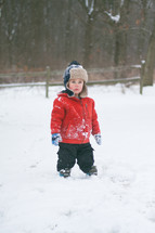 a boy child standing outdoors in snow 