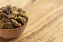 Roasted and Salted Pistachios without Shells on a Wood Table