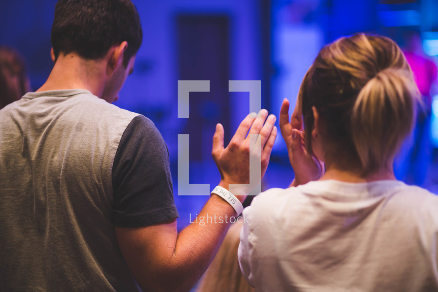 hands raised in worship at a worship service 