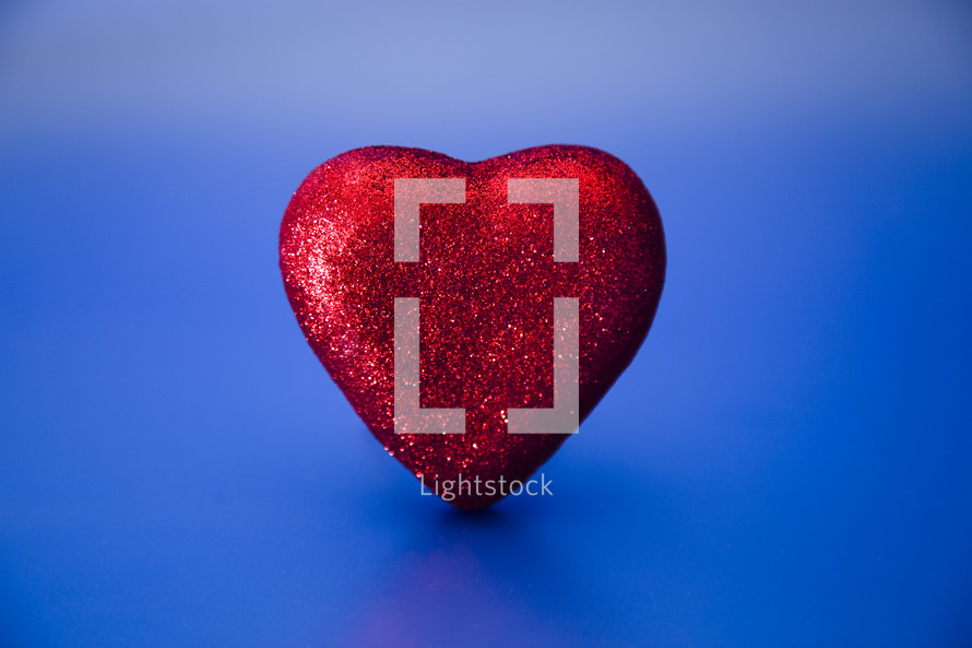 red glittery heart on a blue background 