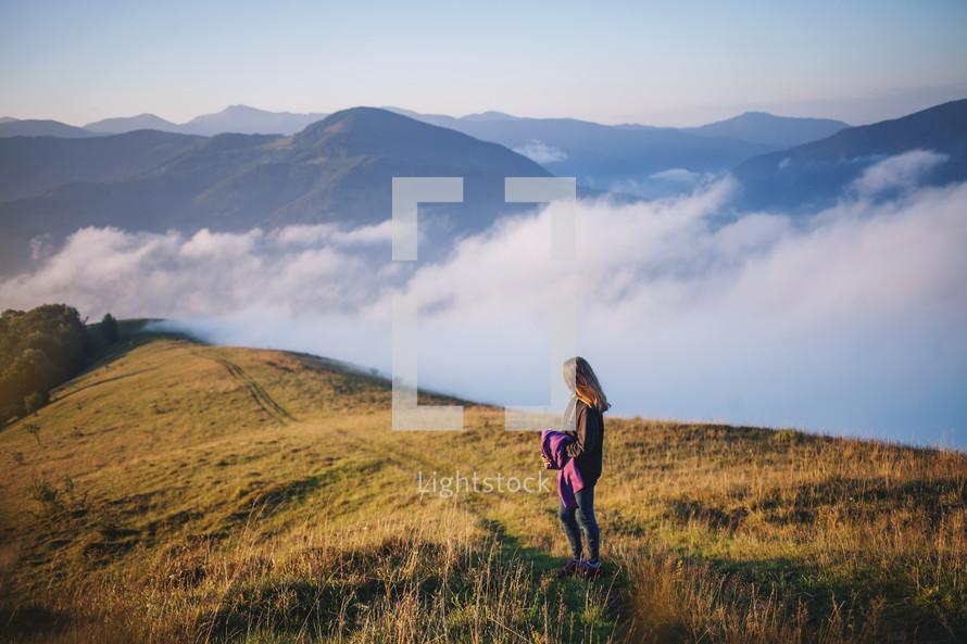 a teen girl walking up a mountainside 