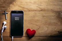 A Bible app on a smart phone with earbuds 