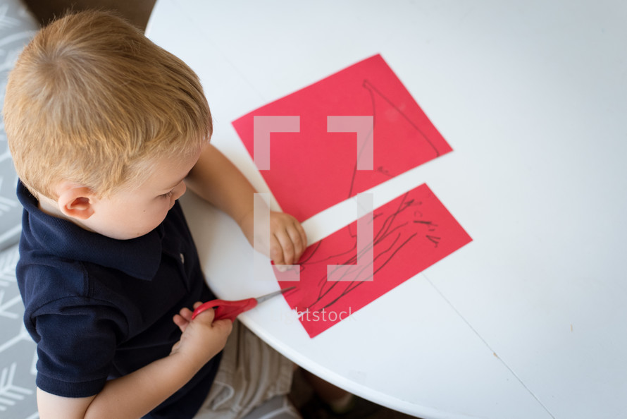 child cutting construction paper 